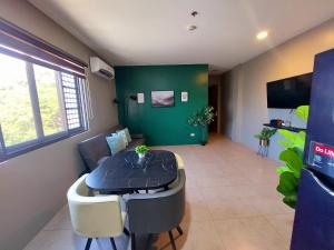 a dining room with a table and a green wall at Minimalist Vigan Condo Near Calle Crisologo in Vigan