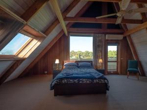 1 dormitorio con 1 cama en una habitación con ventanas en Sunset Dreams across the Sea, en Coronet Bay