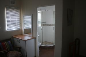 a bathroom with a shower with a toilet and a sink at Hardman Beach House in Port Edward +7 photos