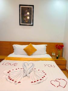 a bed with the words love and wings on it at Hotel Hoàng Lộc Phát in Cái Răng