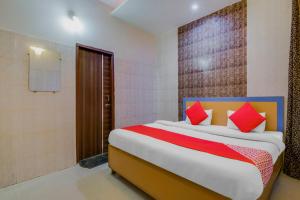um quarto com uma cama grande e almofadas vermelhas em Collection O Goodwill Hotel em Jamu