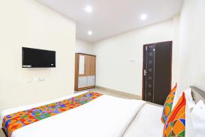 a bedroom with a bed and a flat screen tv at FabExpress Vhyom Sky Palace in Kolkata