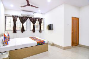 a bedroom with a bed and a ceiling fan at FabExpress Vhyom Sky Palace in Kolkata