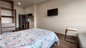 a bedroom with a bed and a tv on the wall at La Milla, Lofts in Chía