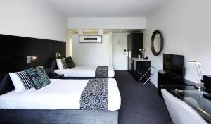 a hotel room with two beds and a flat screen tv at Mercure Tauranga in Tauranga +68 photos