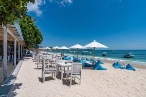 a row of tables and chairs on the beach at Nusa Indah Bungalow in Nusa Lembongan