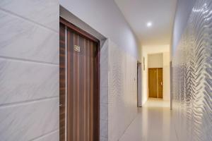 un corridoio con porta in legno in un edificio di Collection O Goodwill Hotel a Jammu
