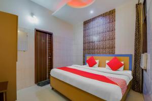 Collection O Goodwill Hotel في جامو: غرفة نوم بسرير كبير ومخدات حمراء