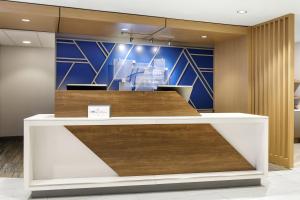 an office lobby with a reception counter with wood at Holiday Inn Express Hocking Hills-Logan by IHG in Logan +37 photos
