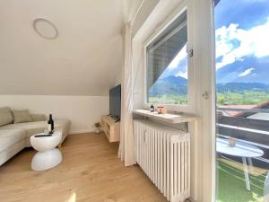 a living room with a couch and a large window at Best Butler Alpspitz Apartment Küche Parken Balkon in Nesselwang