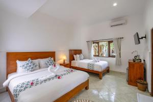 a bedroom with two beds and a window at Nusa Indah Bungalow in Nusa Lembongan
