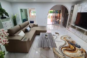 una sala de estar con un sofá y una mesa en KataBeach sweetHome 4br, en Kata Beach