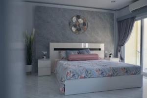 Un dormitorio con una cama grande y una ventana grande. en KataBeach sweetHome 4br, en Kata Beach