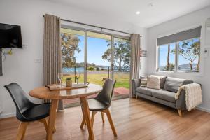 uma sala de estar com uma mesa e cadeiras e um sofá em Tasman Holiday Parks - St Helens em St Helens