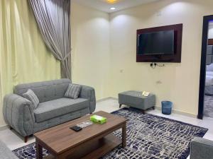 a living room with a couch and a tv at برادايز للشقق المخدومة in Khamis Mushayt