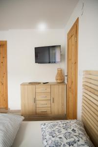 um quarto com uma cama e uma televisão na parede em Pokoje Gościnne "SOSENKA" em Cisna