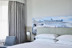 a bedroom with a bed and a painting on the wall at Bournemouth Highcliff Marriott Hotel in Bournemouth