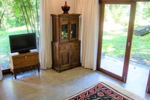 una sala de estar con TV y una cabaña de madera en Cobalt Villa by The Serendipity Collection en Kandy
