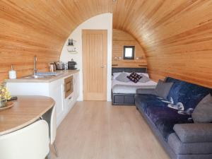 a living room with a couch and a bed in a room at Luna Holiday Pod in Shrewsbury