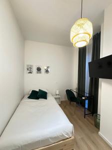 a bedroom with a white bed and a chandelier at IL BALCONE NEL PARCO - stanze con bagno privato in San Donato Milanese