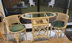 3 sillas de mimbre y una mesa con encimera de cristal en Kiwiblue, en Kerikeri