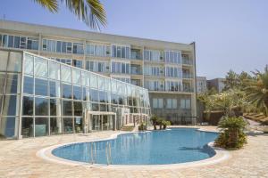 a large building with a swimming pool in front of a building at Phoenix Island in Seogwipo