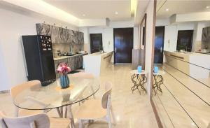 een keuken met een glazen tafel en stoelen bij Regalia Suites with Infinity Pool KLCC by Staycation Homes in Kuala Lumpur