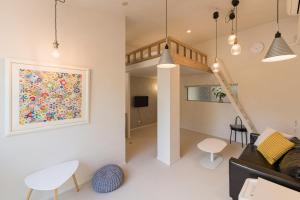 a living room with a couch and a painting on the wall at Flower Base Lily House in Fukuoka