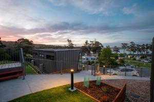 une maison avec une clôture et un banc dans une cour dans l'établissement Tasman Holiday Parks - St Helens, à St Helens