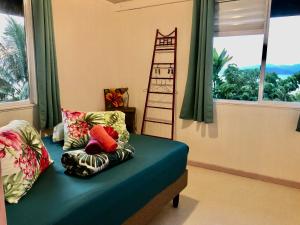 Schlafzimmer mit einem Bett mit einem Kissen und einer Leiter in der Unterkunft Fare Mirimiri in Uturoa