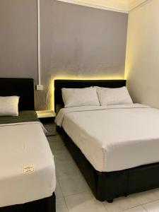 two beds in a hotel room with two bedsskirts at Andiana Hotel & Lodge - Kota Bharu City Centre in Kota Bharu