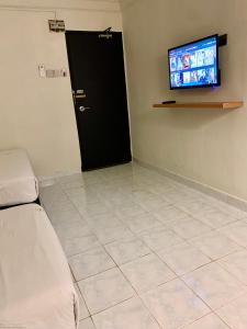 a room with a black door and a television at Andiana Hotel & Lodge - Kota Bharu City Centre in Kota Bharu