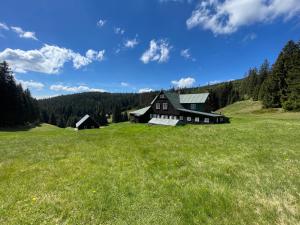 een groot huis in een veld van groen gras bij Bouda Vlkoš in Horní Malá Úpa
