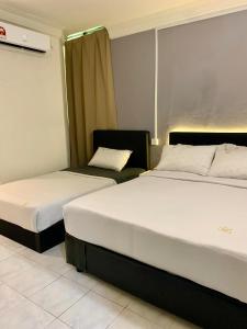 two beds in a hotel room with two beds at Andiana Hotel & Lodge - Kota Bharu City Centre in Kota Bharu