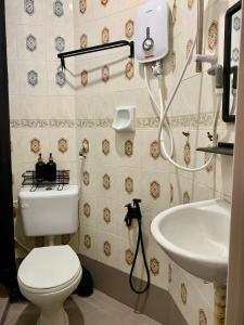 La salle de bains est pourvue de toilettes et d'un lavabo. dans l'établissement Andiana Hotel & Lodge - Kota Bharu City Centre, à Kota Bharu