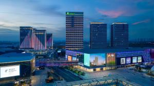Un horizonte de ciudad por la noche con edificios altos en Holiday Inn Tianjin Xiqing by IHG, en Tianjin