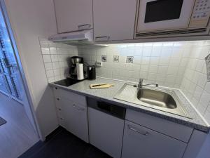a kitchen with a sink and a counter top at Wohnung Südstrand Glück in Fehmarn +16 photos