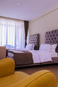 1 dormitorio con 1 cama grande y ventana grande en Hotel Frojd - Beach Front Resort, en Shëngjin