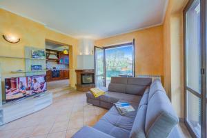 sala de estar con sofá y TV en Il Sole Di Mirasole - Happy Rentals, en Leggiuno