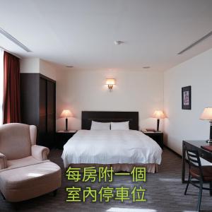 台中市にあるHerkang Hotelのベッドと椅子付きのホテルルーム