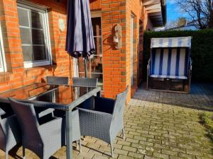 a table and chairs with an umbrella next to a building at Zingstrose Comfortable holiday residence in Zingst