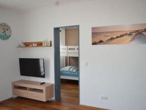 a room with a tv and a bunk bed at Cutter in the shiphouse in Hooksiel