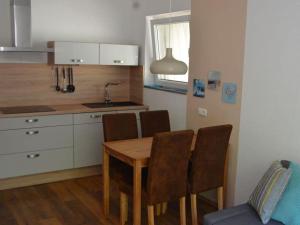 a kitchen with a wooden table and chairs in a room at Cutter in the shiphouse in Hooksiel