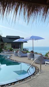 a swimming pool with lounge chairs and an umbrella at Phangan Utopia Resort in Mae Haad