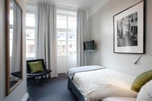 um quarto de hotel com uma cama e uma cadeira e uma janela em Hotel Örebro em Örebro