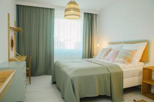a bedroom with a bed and a large window at Apart Harmony- Apartament Kaprów 6 in Puck