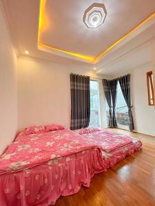 a bedroom with a large bed with a red comforter at Teras Senja Sikunir Homestay in Kejajar