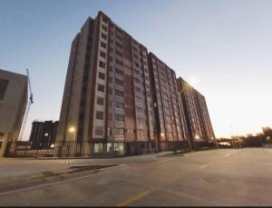 a large building with a parking lot in front of it at Ap al lado Unorte 10Min B/vista Vista a la cienaga in Puerto Colombia