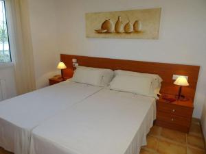 una camera da letto con un letto bianco e due lampade di Casa Ayelen Comfortable holiday residence a Vinarós Altre 15 foto