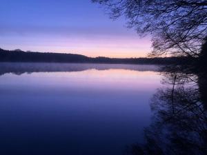a view of a large lake at sunset at Lake idyll Comfortable holiday residence in Repente